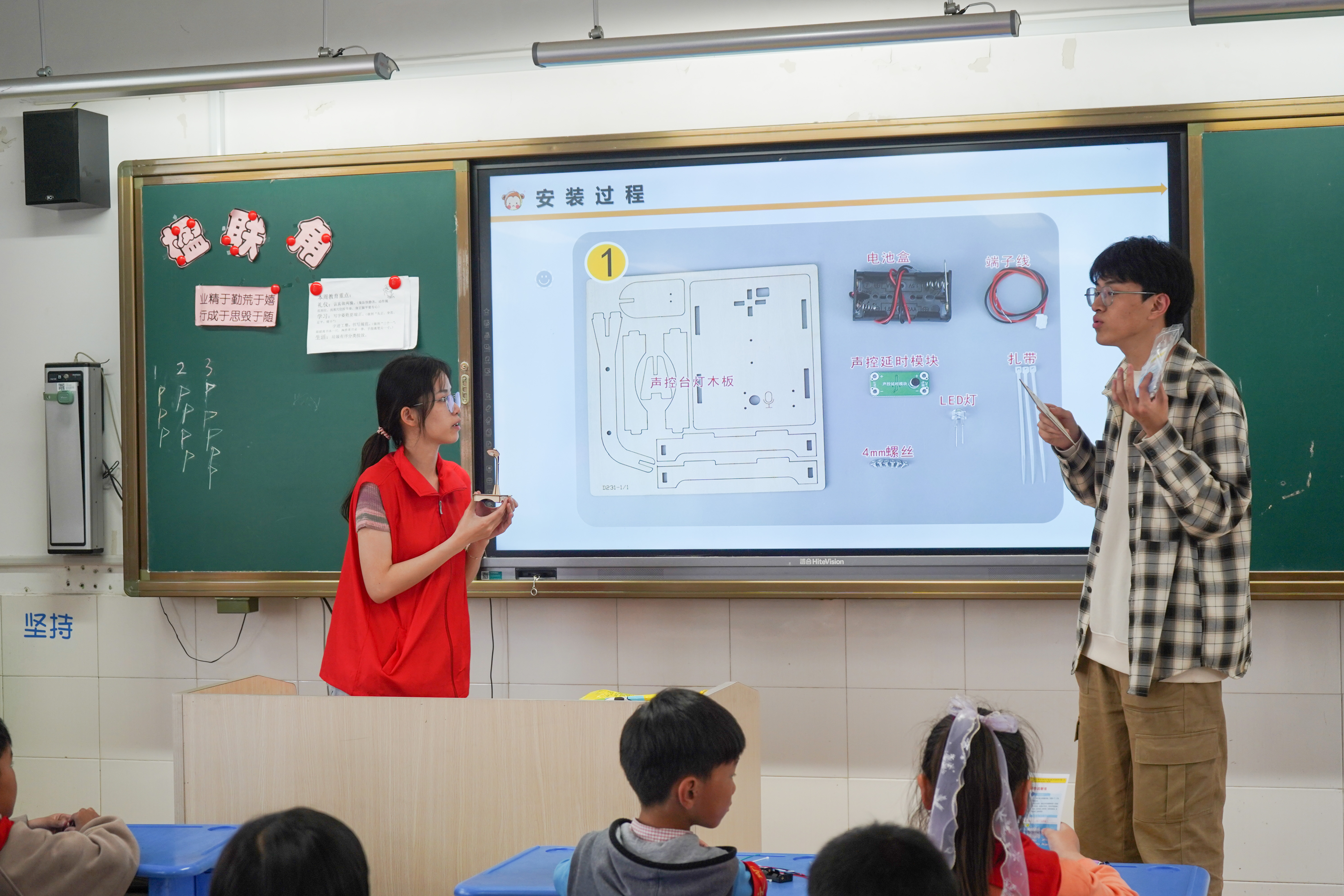 图为乐竞在线平台(中国)官网自动化学院志愿者冯靖茹、蔡志锦为镇江市润商小学二年级一班同学讲解声控灯原理.JPG