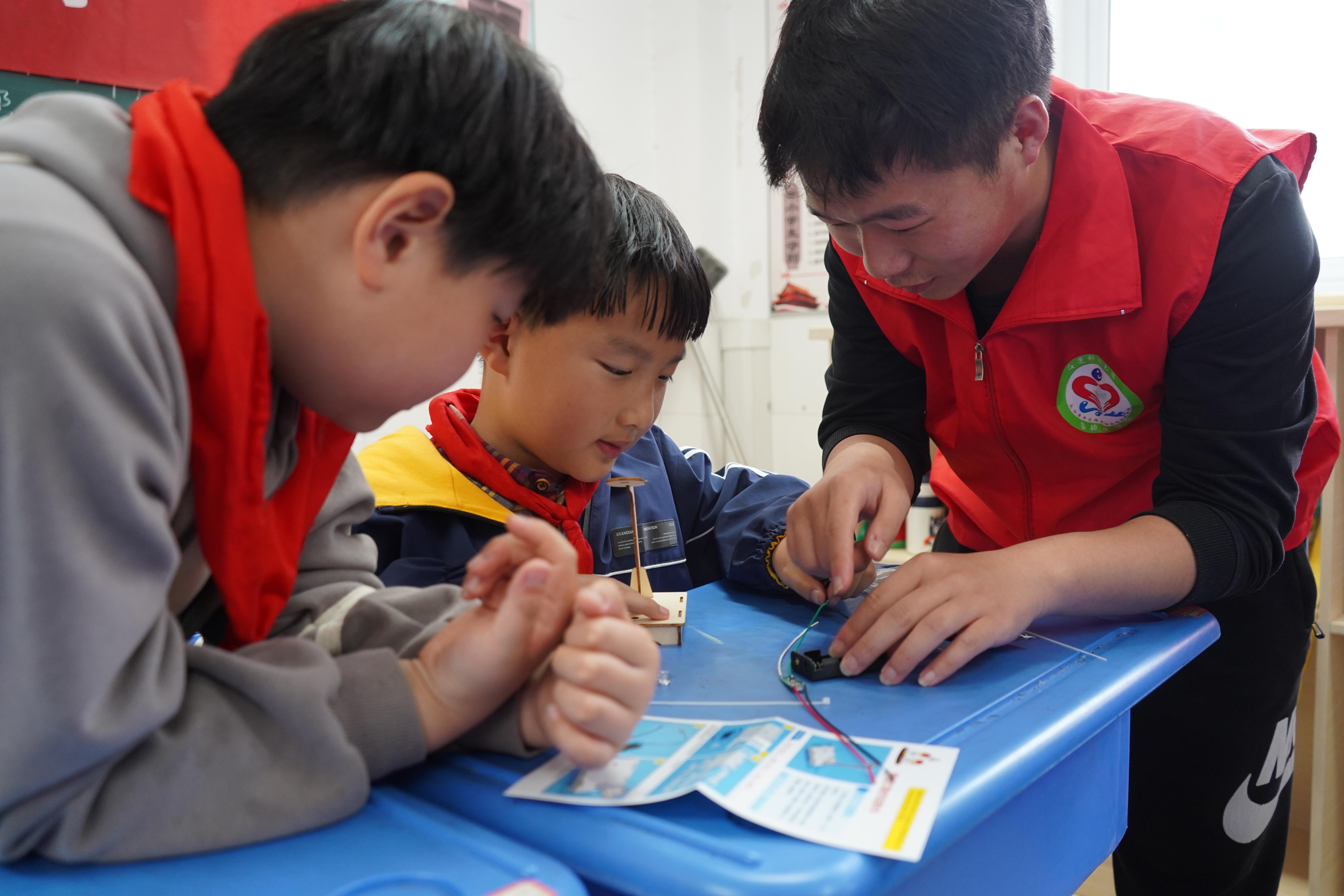 图为乐竞在线平台(中国)官网自动化学院志愿者吕东航帮助润商小学二年级一班同学拼接组装模型.JPG