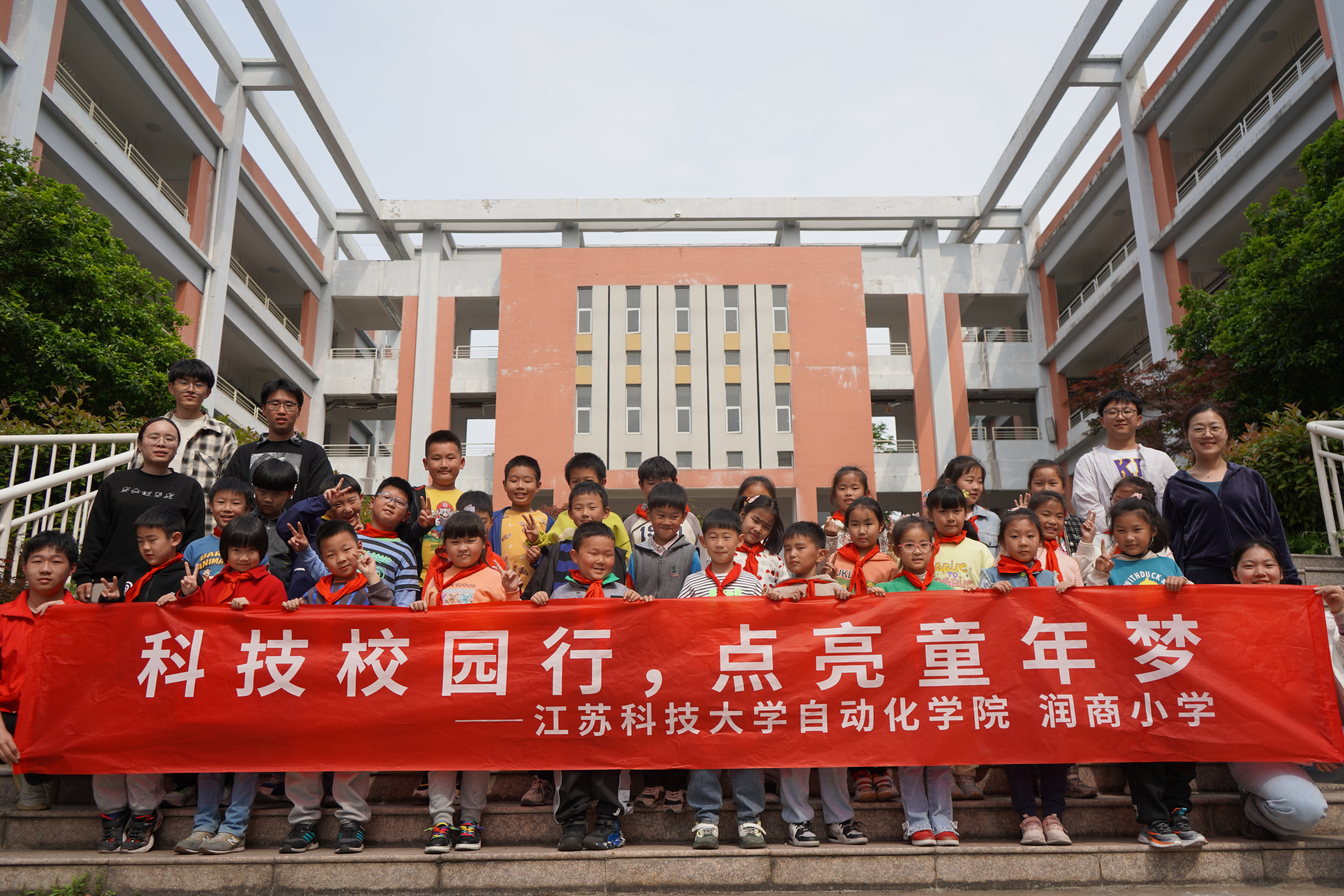 图为乐竞在线平台(中国)官网自动化学院志愿者同镇江市润商小学二年级一班同学拍照合影留念.JPG