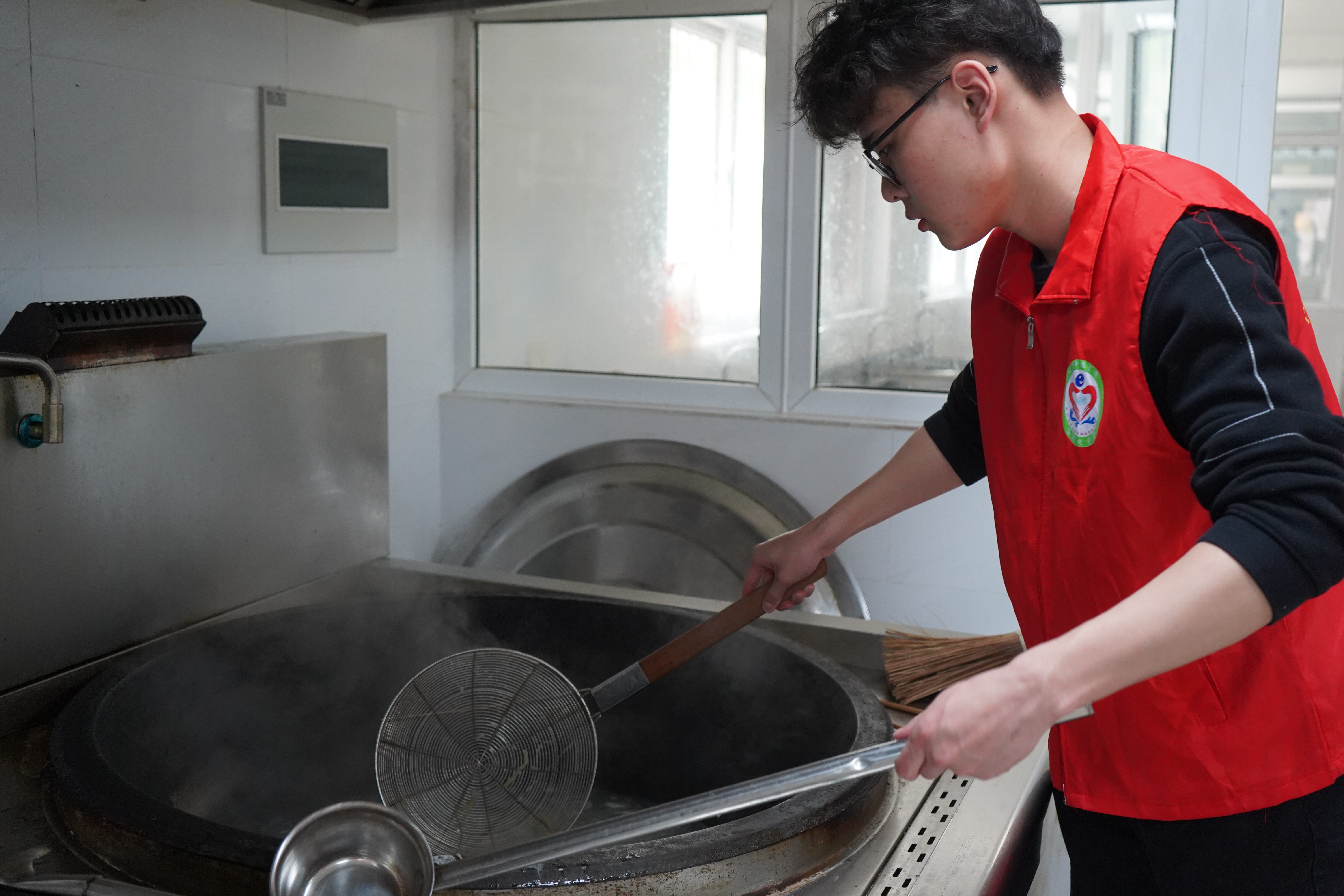 图为乐竞在线平台(中国)官网自动化学院志愿者樊子轩为镇江市润商小学一年级一班同学准备材料，煮开面条.JPG